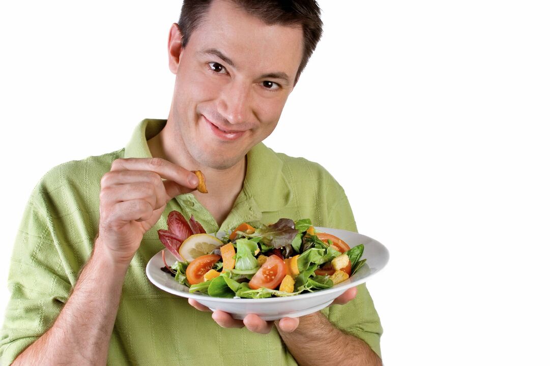 mannen spiser grønnsaksalat for styrken