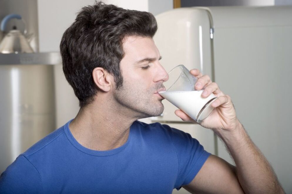 En mann drikker melk